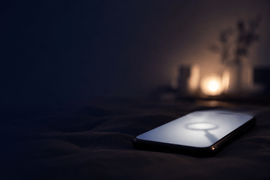 A phone screen glowing softly in a dim room, slightly out of focus