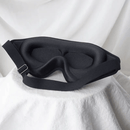 Black sleep mask on a white fabric background